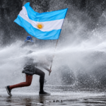 Reelaboración editorial con IA: una persona sostiene una bandera argentina mientras resiste un chorro de agua.